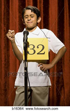 Picture - Boy standing at microphone with eyes closed and number on chest. Fotosearch