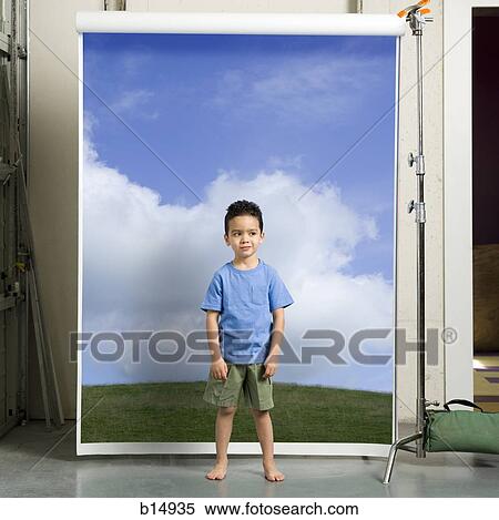 Boy standing in front of screen with blue sky and grass View Large Photo Image Stock Photography - Boy standing in front of screen with blue sky and grass. Fotosearch