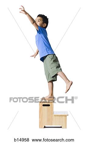 Boy standing on wooden step reaching View Large Photo Image Stock Photo - Boy standing on wooden step reaching. Fotosearch