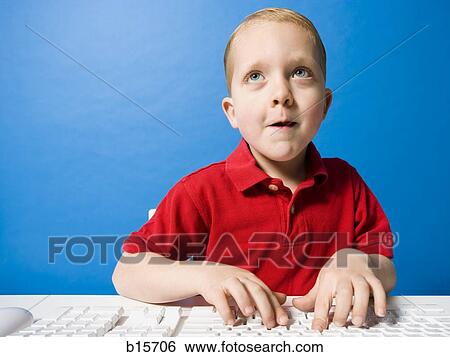 Boy typing at keyboard looking up View Large Photo Image Stock Photograph - Boy typing at keyboard looking up. Fotosearch
