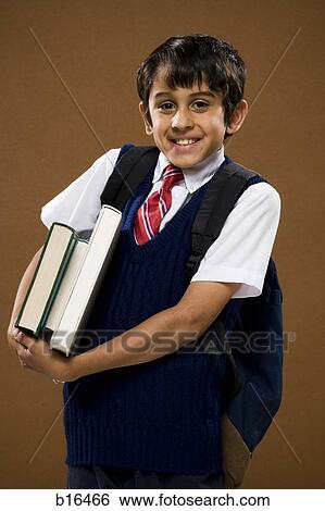 Boy with backpack holding textbooks smiling View Large Photo Image Stock Photograph - Boy with backpack holding textbooks smiling. Fotosearch