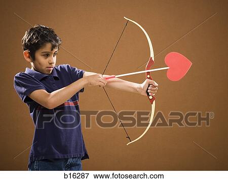 Stock Photo - Boy with bow and arrow with heart on it. Fotosearch