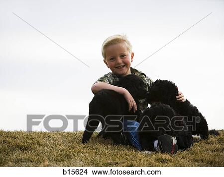 Boy with puppies outdoors View Large Photo Image Picture - Boy with puppies outdoors. Fotosearch