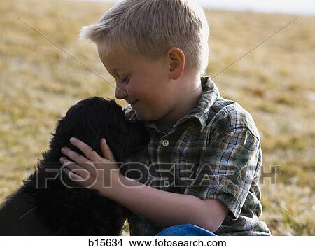 Picture - Boy with puppy outdoors. Fotosearch