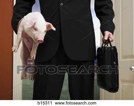 Businessman holding briefcase and piglet View Large Photo Image Stock Image - Businessman holding briefcase and piglet. Fotosearch