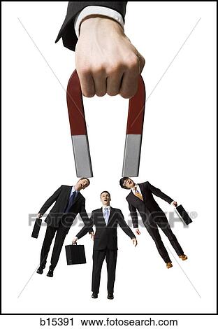 Businessman holding magnet with three businessmen View Large Photo Image Stock Image - Businessman holding magnet with three businessmen. Fotosearch