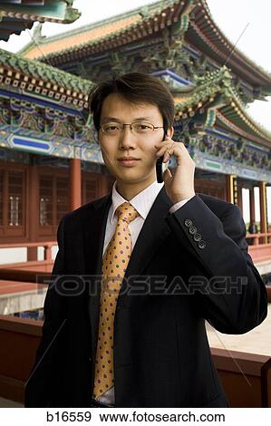 Businessman on cell phone in Asia smiling View Large Photo Image Stock Photo - Businessman on cell phone in Asia smiling. Fotosearch