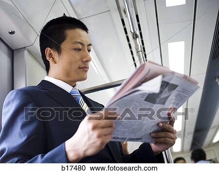 Businessman on subway or bus with newspaper smiling View Large Photo Image Stock Image - Businessman on subway or bus with newspaper smiling. Fotosearch