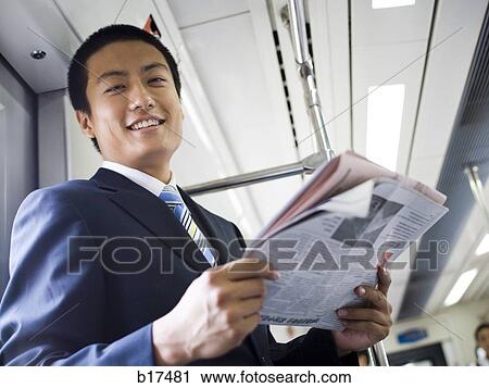 Businessman on subway or bus with newspaper smiling View Large Photo Image Stock Image - Businessman on subway or bus with newspaper smiling. Fotosearch