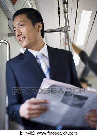 Businessman on subway or bus with newspaper smiling View Large Photo Image Stock Image - Businessman on subway or bus with newspaper smiling. Fotosearch