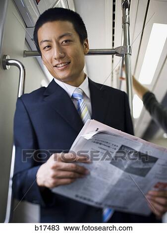 Businessman on subway or bus with newspaper smiling View Large Photo Image Stock Image - Businessman on subway or bus with newspaper smiling. Fotosearch