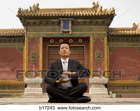 Businessman sitting cross legged outdoors meditating View Large Photo Image Stock Image - Businessman sitting cross legged outdoors meditating. Fotosearch