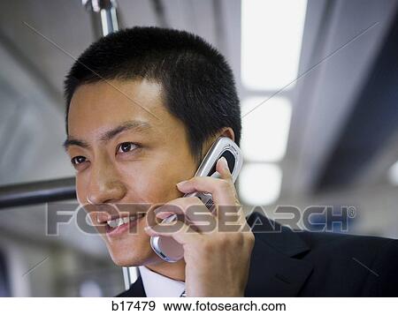 Businessman talking on cell phone smiling View Large Photo Image Stock Photo - Businessman talking on cell phone smiling. Fotosearch