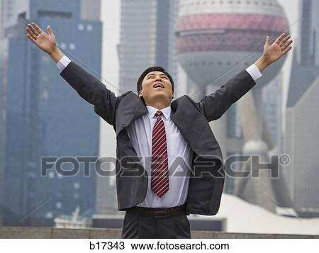 Businessman with arms up and city skyline in background View Large Photo Image Stock Image - Businessman with arms up and city skyline in background. Fotosearch