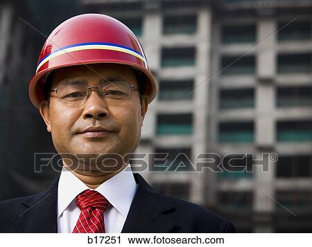 Businessman with construction helmet outdoors View Large Photo Image Stock Image - Businessman with construction helmet outdoors. Fotosearch