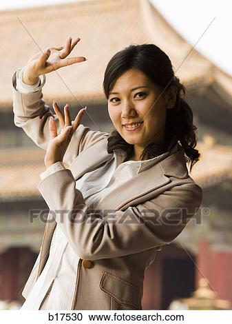 Businesswoman doing tai chi outdoors smiling View Large Photo Image Stock Image - Businesswoman doing tai chi outdoors smiling. Fotosearch
