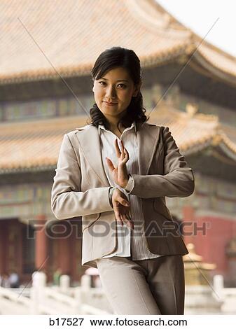 Businesswoman doing tai chi outdoors smiling View Large Photo Image Stock Photo - Businesswoman doing tai chi outdoors smiling. Fotosearch