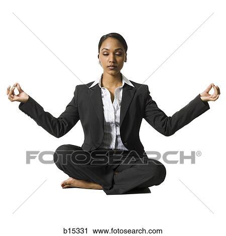 Stock Image - Businesswoman sitting cross legged doing yoga. Fotosearch
