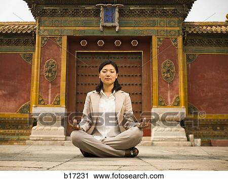 Businesswoman sitting cross legged outdoors meditating View Large Photo Image Stock Image - Businesswoman sitting cross legged outdoors meditating. Fotosearch