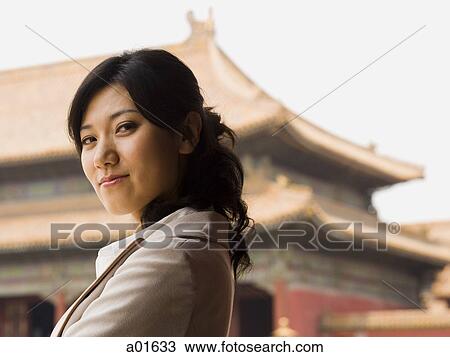 Businesswoman smiling outdoors with pagoda in background View Large Photo Image Stock Image - Businesswoman smiling outdoors with pagoda in background. Fotosearch