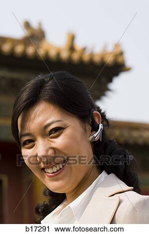 Businesswoman smiling outdoors with headset View Large Photo Image Stock Image - Businesswoman smiling outdoors with headset. Fotosearch