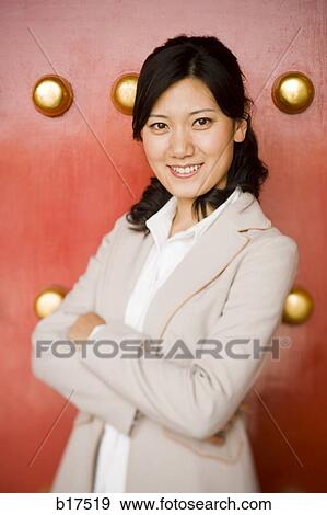 Businesswoman standing with arms crossed smiling View Large Photo Image Stock Photo - Businesswoman standing with arms crossed smiling. Fotosearch
