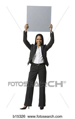 Businesswoman standing with blank sign over head View Large Photo Image Stock Photograph - Businesswoman standing with blank sign over head. Fotosearch