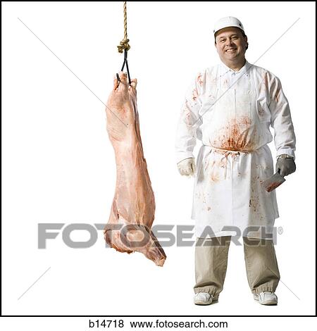 Butcher standing with hanging carcass and knife View Large Photo Image Stock Photo - Butcher standing with hanging carcass and knife. Fotosearch