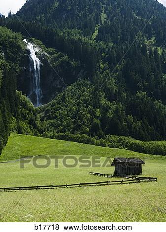 Cabin in valley with mountains and waterfall View Large Photo Image Stock Photo - Cabin in valley with mountains and waterfall. Fotosearch