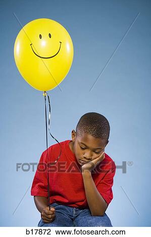 Stock Image - Child holding a balloon.. Fotosearch