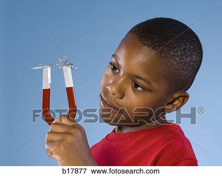 Stock Photo - Child holding a magnet.. Fotosearch