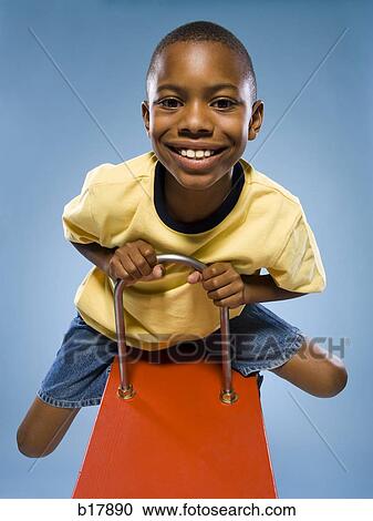 Child riding on a see saw. View Large Photo Image Stock Image - Child riding on a see saw.. Fotosearch