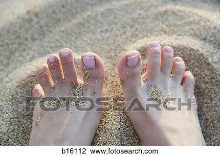Stock Image - Close-up of toes in sand. Fotosearch