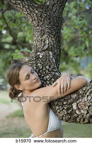Close-up of woman hugging tree outdoors View Large Photo Image Stock Image - Close-up of woman hugging tree outdoors. Fotosearch