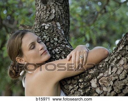 Close-up of woman hugging tree outdoors View Large Photo Image Stock Image - Close-up of woman hugging tree outdoors. Fotosearch