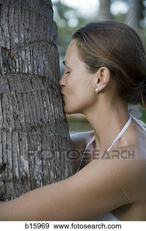 Close-up of woman kissing tree outdoors View Large Photo Image Stock Photo - Close-up of woman kissing tree outdoors. Fotosearch