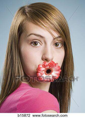 Close-up of woman with flower in her mouth View Large Photo Image Stock Image - Close-up of woman with flower in her mouth. Fotosearch