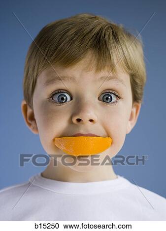 Closeup of boy eating orange wedge View Large Photo Image Stock Image - Closeup of boy eating orange wedge. Fotosearch