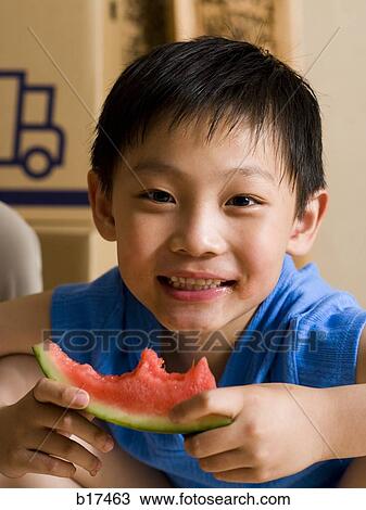 Stock Image - Closeup of boy eating watermelon. Fotosearch