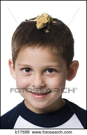 Stock Photo - Closeup of boy with lizard on head smiling. Fotosearch