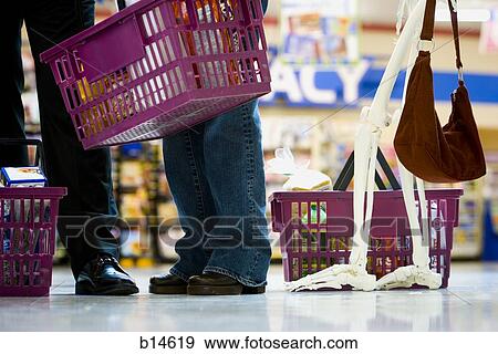 Closeup of feet and skeleton in grocery store line with shopping baskets View Large Photo Image Stock Photo - Closeup of feet and skeleton in grocery store line with shopping baskets. Fotosearch