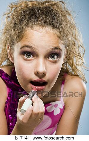Stock Image - Closeup of girl applying lipstick. Fotosearch