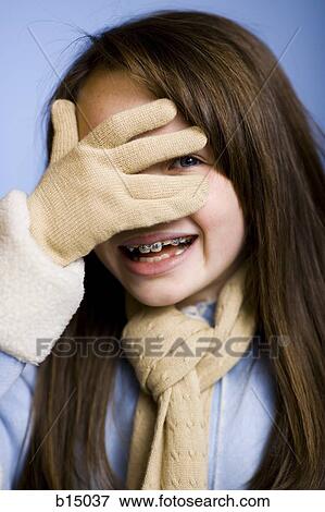 Closeup of girl with braces smiling and covering eye View Large Photo Image Stock Photo - Closeup of girl with braces smiling and covering eye. Fotosearch