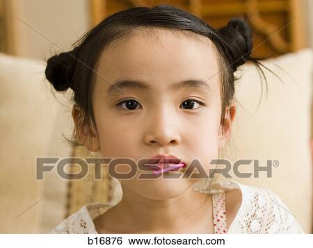 Stock Photograph - Closeup of girl with lollipop in mouth. Fotosearch