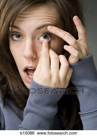 Closeup of woman inserting contact lens View Large Photo Image Stock Photograph - Closeup of woman inserting contact lens. Fotosearch