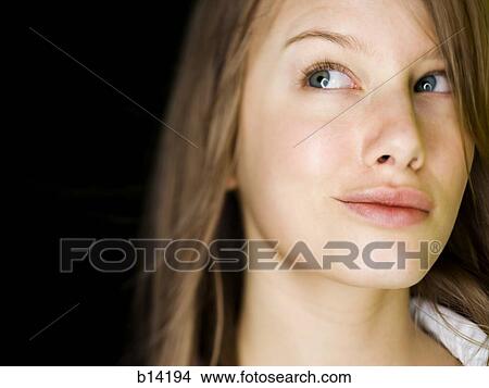 Closeup of woman smirking and looking up View Large Photo Image Picture - Closeup of woman smirking and looking up. Fotosearch