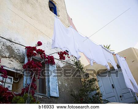Clothes hanging on clothesline with building and flowers View Large Photo Image Stock Image - Clothes hanging on clothesline with building and flowers. Fotosearch