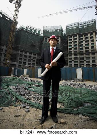 Construction site foreman with blueprints outdoors View Large Photo Image Stock Photo - Construction site foreman with blueprints outdoors. Fotosearch