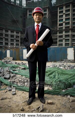Stock Photo - Construction site foreman with blueprints outdoors. Fotosearch