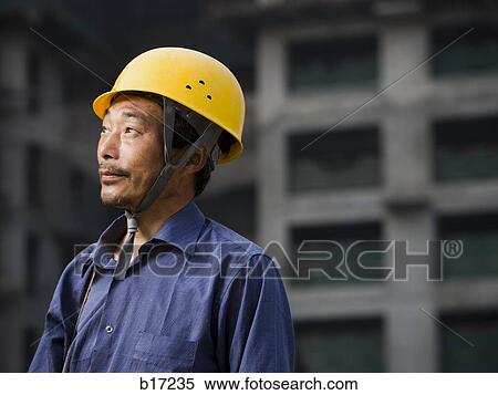Construction worker with helmet outdoors looking up View Large Photo Image Stock Photography - Construction worker with helmet outdoors looking up. Fotosearch